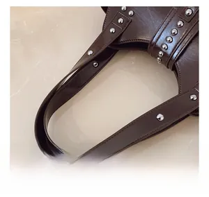 Gros plan détaillé de la bandoulière en cuir PU marron et des rivets sur le sac à main