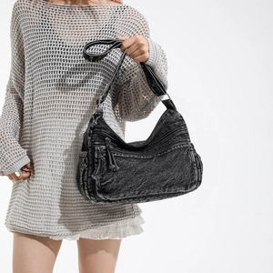 Vintage washed black denim crossbody bag with multi-zipper pockets and fringe details