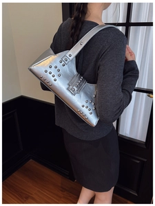Détail d'un sac sous le bras argenté métallique avec rivets décoratifs et style Y2K