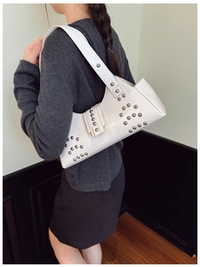 Détail du sac à bandoulière en cuir blanc avec clous argentés et style punk rétro chic