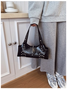 Détail d'un sac à main noir en cuir huilé vintage avec rivets argentés décoratifs