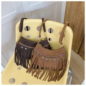 Détail de sacs bandoulière bohèmes à franges avec rubans jacquard et pièces en métal