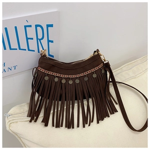 Détail d'un sac à bandoulière ethnique avec franges et décorations de pièces vintage