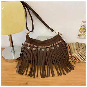 Détail du sac bandoulière ethnique marron avec franges et pendentifs métalliques
