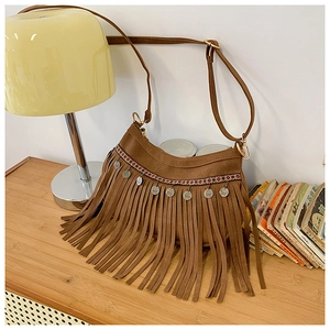 Détail du sac à bandoulière marron à franges avec ruban ethnique et pièces argentées