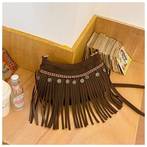 Détail du sac croissant bohème avec broderie ethnique, pompons et pièces en métal