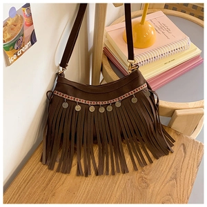 Détail du sac bohème marron foncé à franges avec sangle ethnique et breloques en métal
