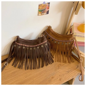 Détail de sacs bandoulière bohèmes avec motifs ethniques et longues franges fluides