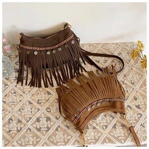 Détails des franges ethniques et broderies bohèmes sur les sacs en daim marron