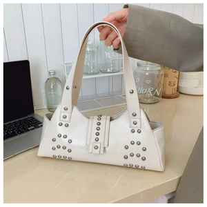 Détail du sac à bandoulière en cuir blanc crème avec rivets argentés et boucle de fermeture