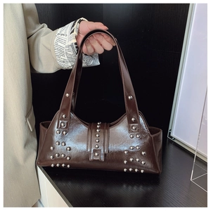 Détail du sac bandoulière en cuir verni marron foncé avec clous argentés et boucle