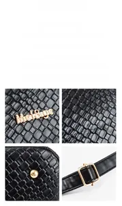 Detail of black woven texture leather tote with gold logo and adjustable shoulder strap