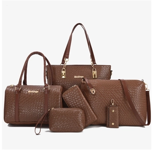 Macro detail of dark brown embossed woven leather bags with golden metal hardware set
