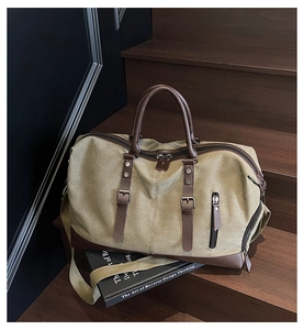Detailed close-up of high-density olive canvas travel bag with premium leather trim and buckles
