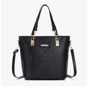 Detail of black embossed tote bag featuring woven texture and gold chain hardware
