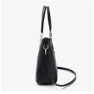 Side view of black faux leather tote with crocodile embossing and gold hardware