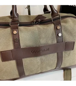 Detailed close-up of large olive canvas travel bag with premium brown leather handles