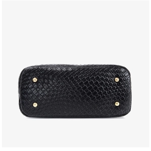 Detail view of woven black PU tote bag base with four protective gold metal feet