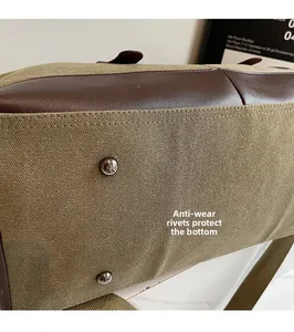 Detail view of military green canvas travel bag base with silver anti-wear metal rivets