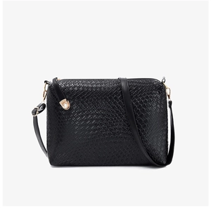 Detail of black faux leather tote with snakeskin texture and golden rotating clasp closure