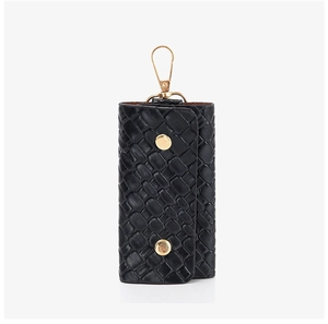 Detail of black woven texture keychain bag with gold lobster clasp and snap buttons