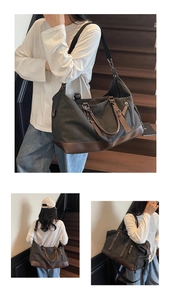 Detail view of large grey canvas travel bag with brown leather base and metal zippers