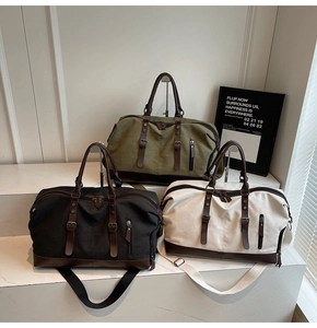 Three large canvas travel bags in green, black, and beige with leather handles and straps