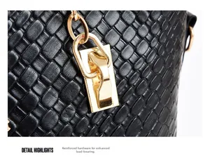 Detail of reinforced gold-tone hardware and embossed texture on black tote bag