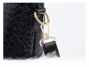 Macro detail of embossed crocodile leather and golden detachable shoulder strap hooks