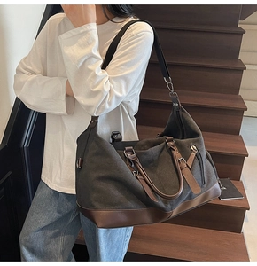 Close-up of charcoal canvas travel bag with leather accents and durable handles