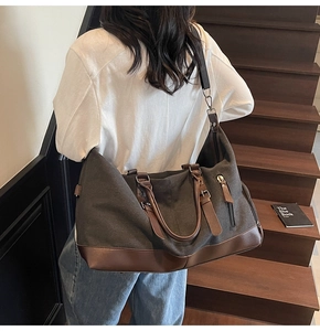 Close-up of a large canvas travel bag with leather trim on a stylish wooden staircase