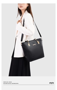 Close-up of black woven tote bag with gold buckle hardware on a professional model