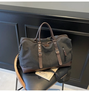 Close-up of large canvas travel bag with leather straps on a vintage chair