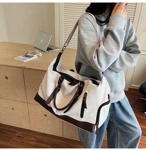 Detail of large canvas travel bag with premium leather trim and side zipper pocket