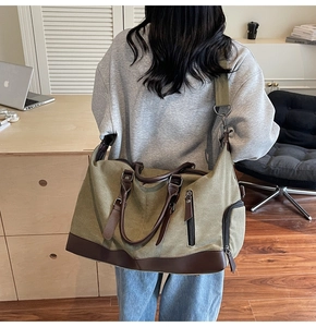 Detailed side view of an olive green travel bag showing straps and leather reinforcement