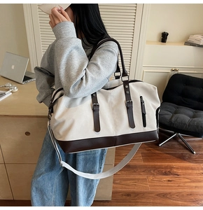 Detail of canvas travel bag with leather trim and adjustable shoulder strap for women