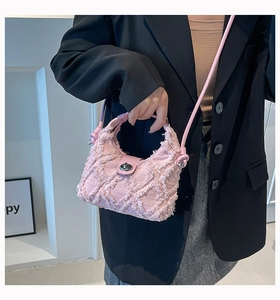 Dettaglio della borsa rosa con frange, trama intrecciata e chiusura a girello argentata