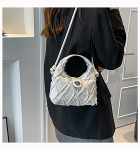 Dettaglio borsa a tracolla in denim bianco con bordi sfilacciati e chiusura in metallo