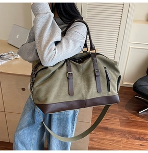 Olive green travel bag detail showing leather handles and adjustable shoulder strap