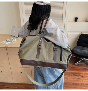 Olive green canvas travel bag featuring premium brown leather trim and metal hardware details