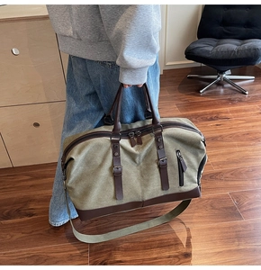 Close-up of large canvas travel bag with leather handles shown in a lifestyle setting