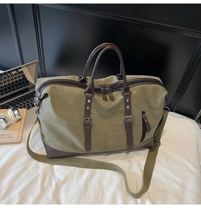 Detail of army green travel bag showing thick canvas texture and brown leather trim