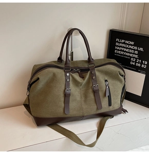 Macro view of army green canvas travel bag with brown leather handles and metal buckles