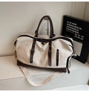 Detail of canvas travel bag with brown leather trim and sturdy adjustable shoulder strap
