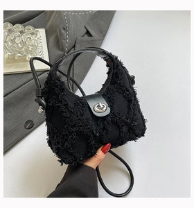 Dettaglio della borsa in denim nero antracite con frange e chiusura a girello in argento