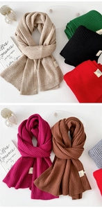 Detailed close-up of ribbed knit texture on a thick winter scarf made of soft blended yarn