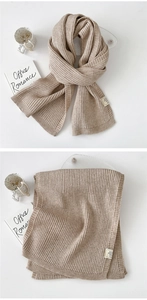 Macro shot of oatmeal knit scarf texture with care label and thick ribbed pattern