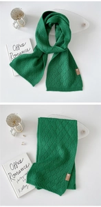 Detailaufnahme des dunkelgrünen Strickschals mit Rautenmuster und Leder-Patch-Akzent