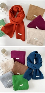 Close-up of 100% pure wool knitted scarf texture with premium ribbed edge and woven label