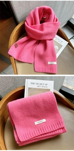 Detail of bright pink 100% wool knitted scarf showing wide ribbed texture and soft fabric